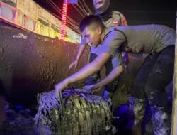 Personel Polri Bersihkan Lumpur dan Sampah Pascabanjir di Jalan Lintas Aceh Tamiang
